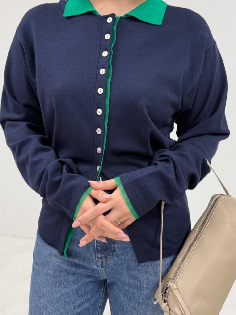 ブルー系のデニムパンツ、ベージュ系のボストンバッグ、ブルー系のカーディガン/ボレロを着用したレディースの冬コーディネートの3枚目の写真