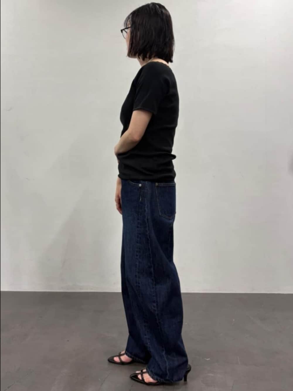 ブラック系のTシャツ/カットソー、ブルー系のデニムパンツを着用したレディースの夏コーディネートの2枚目の写真