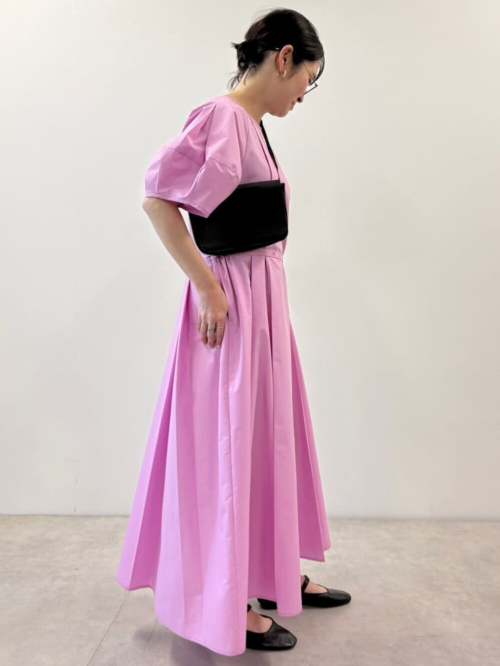 ブラック系のボディバッグ/ウエストポーチ、ピンク系のワンピースを着用したレディースの春コーディネートの2枚目の写真