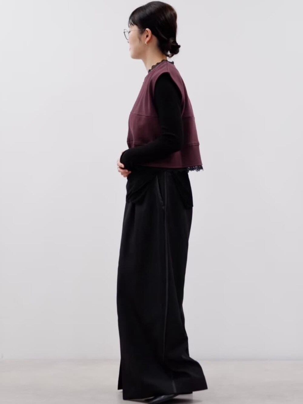 ブラウン系のベスト、ブラック系のスラックスを着用したレディースの秋コーディネートの2枚目の写真