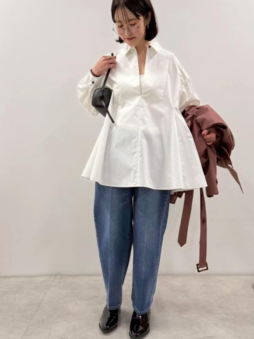 ブラック系のローファー、ホワイト系のシャツ/ブラウス、ブラック系のボストンバッグを着用したレディースの冬コーディネートの2枚目の写真