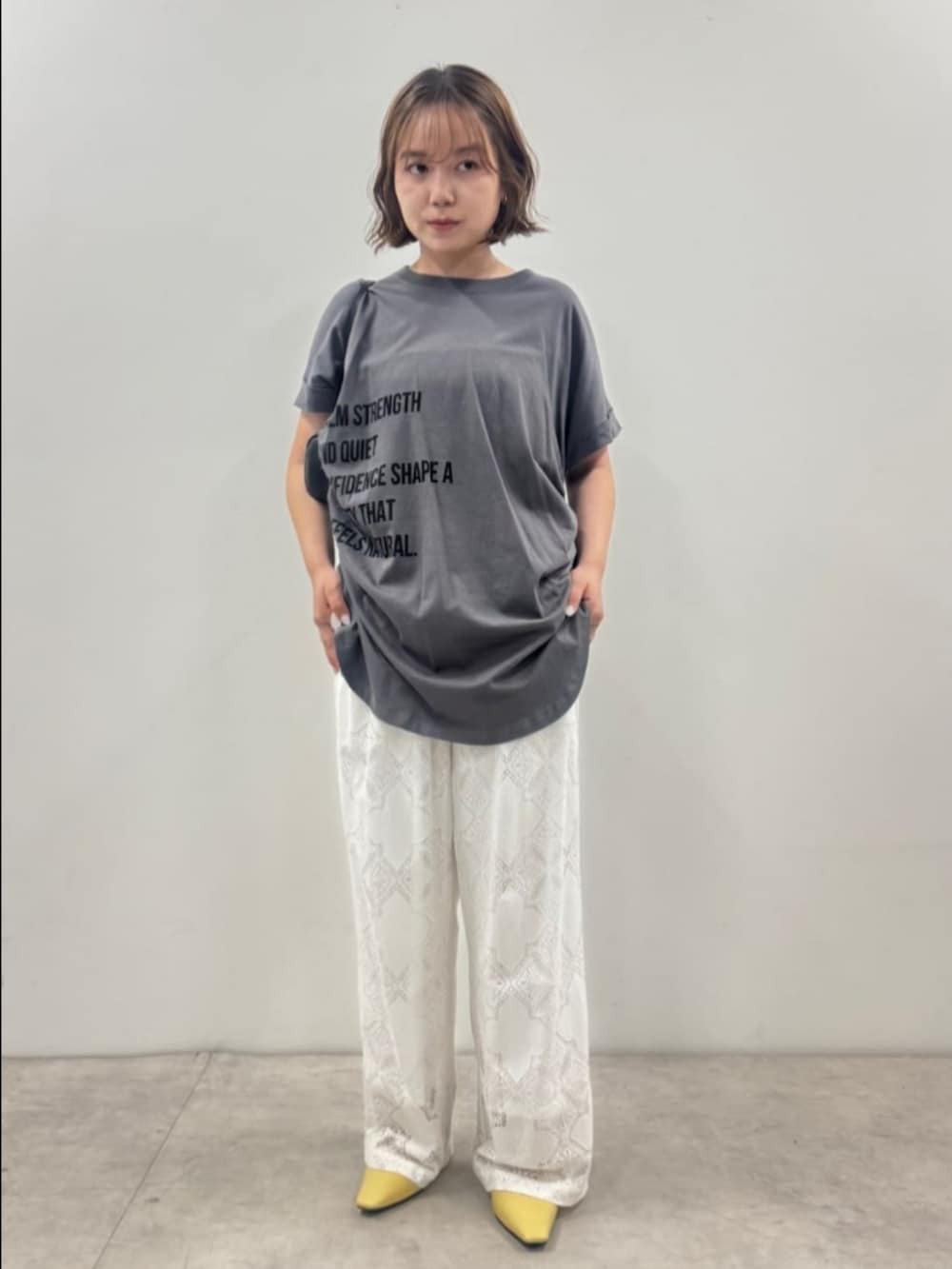 グレー系のTシャツ/カットソー、ホワイト系のその他パンツ、ブラック系のボストンバッグを着用したレディースの夏コーディネートの2枚目の写真
