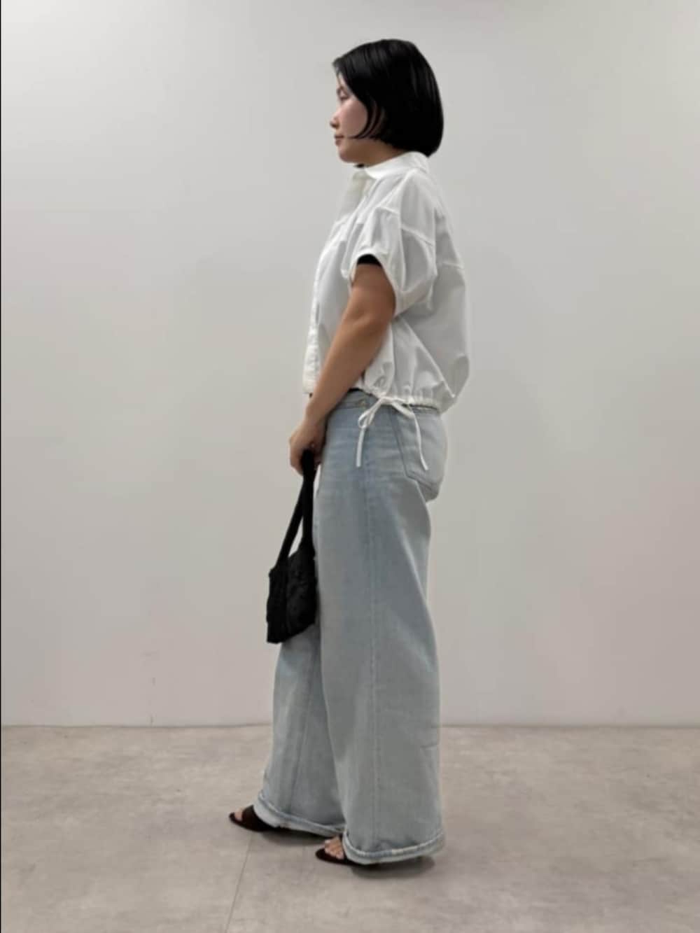 ホワイト系のシャツ/ブラウス、ブラック系のTシャツ/カットソー、ブラック系のハンドバッグを着用したレディースの夏コーディネートの2枚目の写真