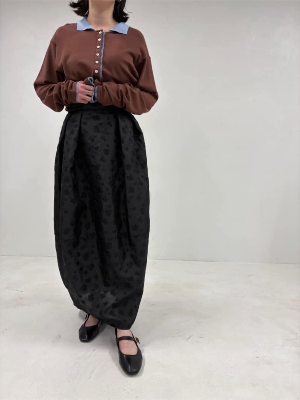 ブラウン系のカーディガン/ボレロ、ブラック系のスカートを着用したレディースの冬コーディネートの5枚目の写真