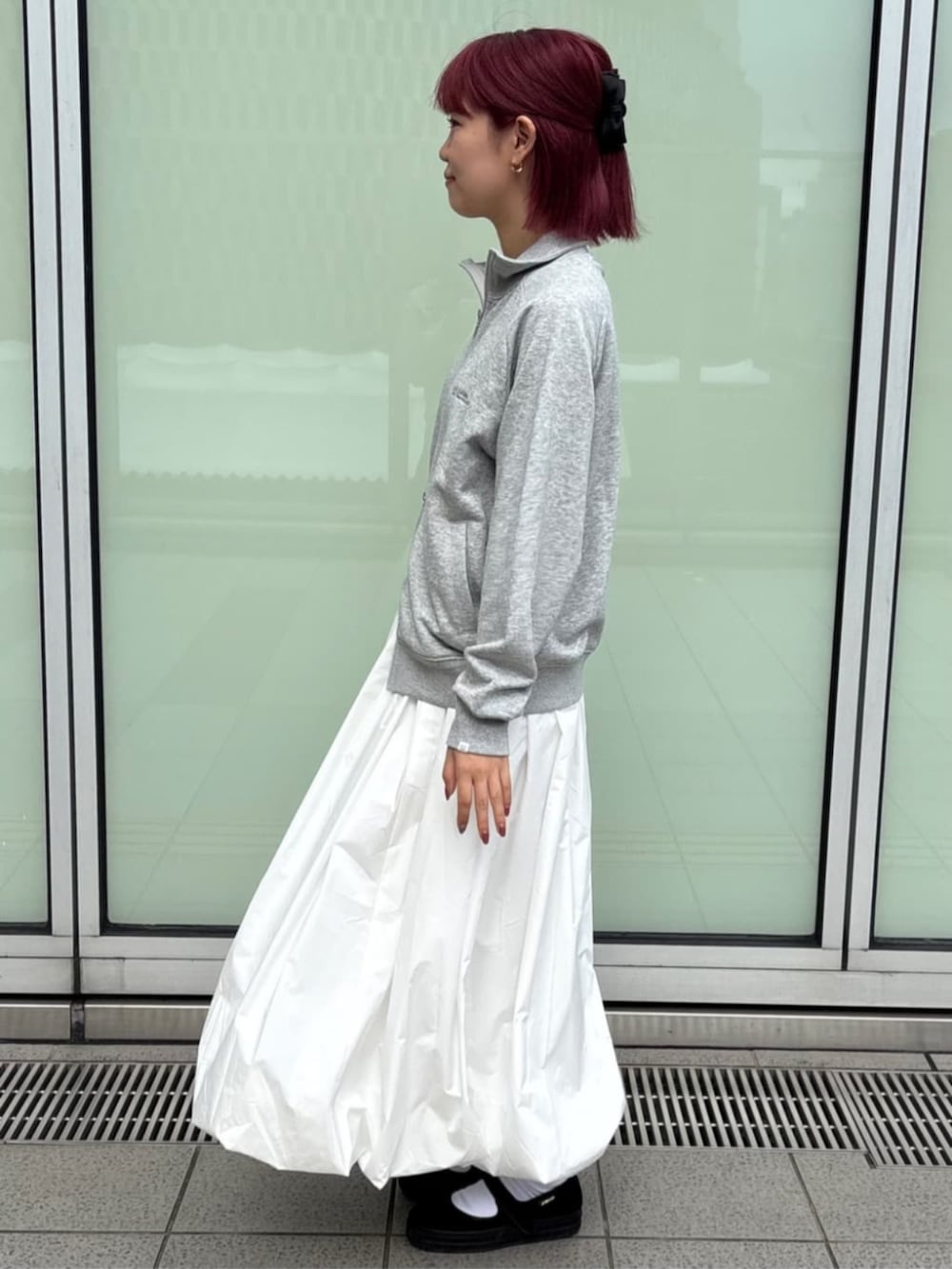 ホワイト系のスカート、グレー系のカーディガン/ボレロを着用したレディースの秋コーディネートの2枚目の写真