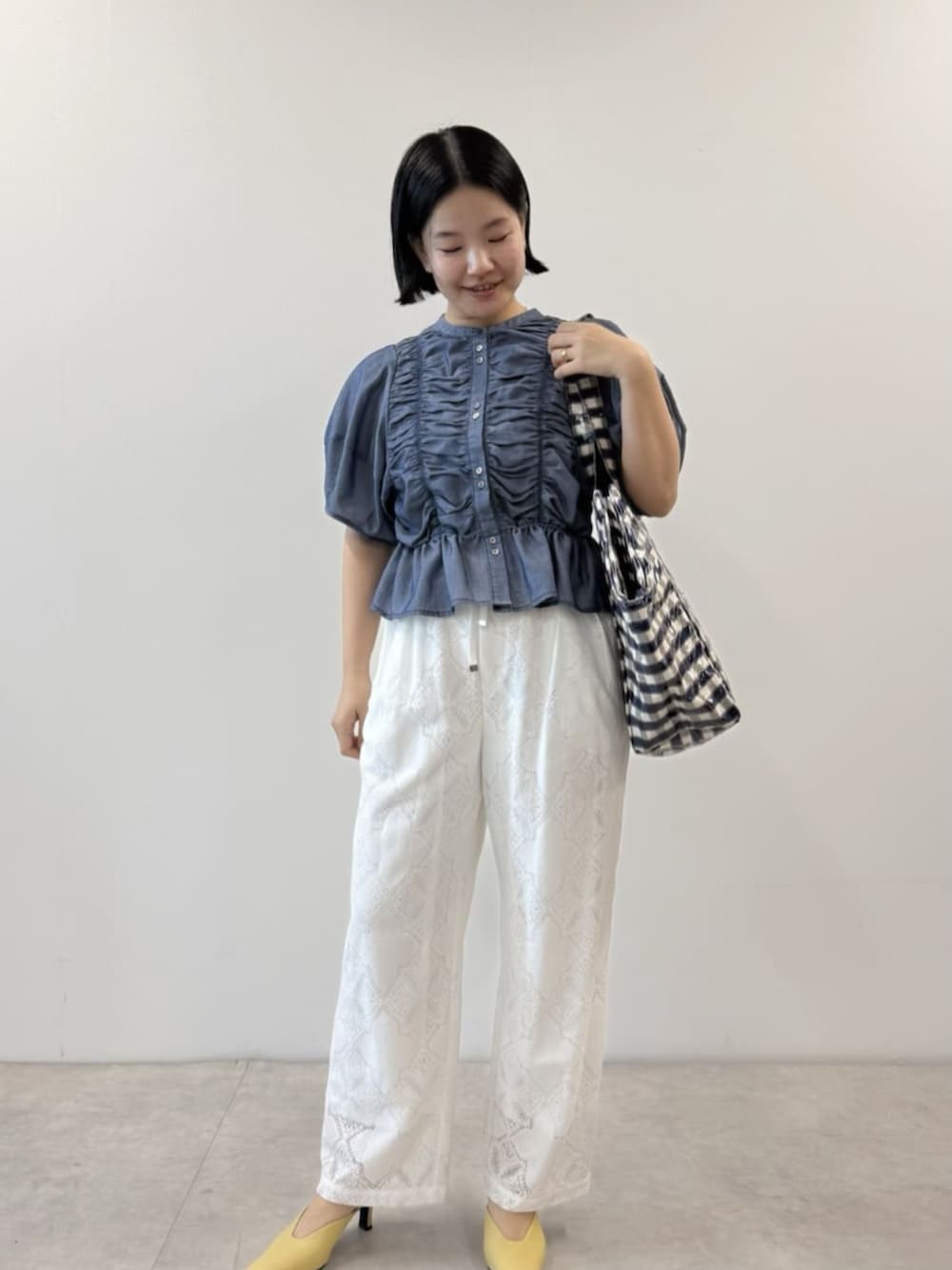 ブルー系のシャツ/ブラウス、ブルー系のトートバッグ、ホワイト系のデニムパンツを着用したレディースの春コーディネートの2枚目の写真