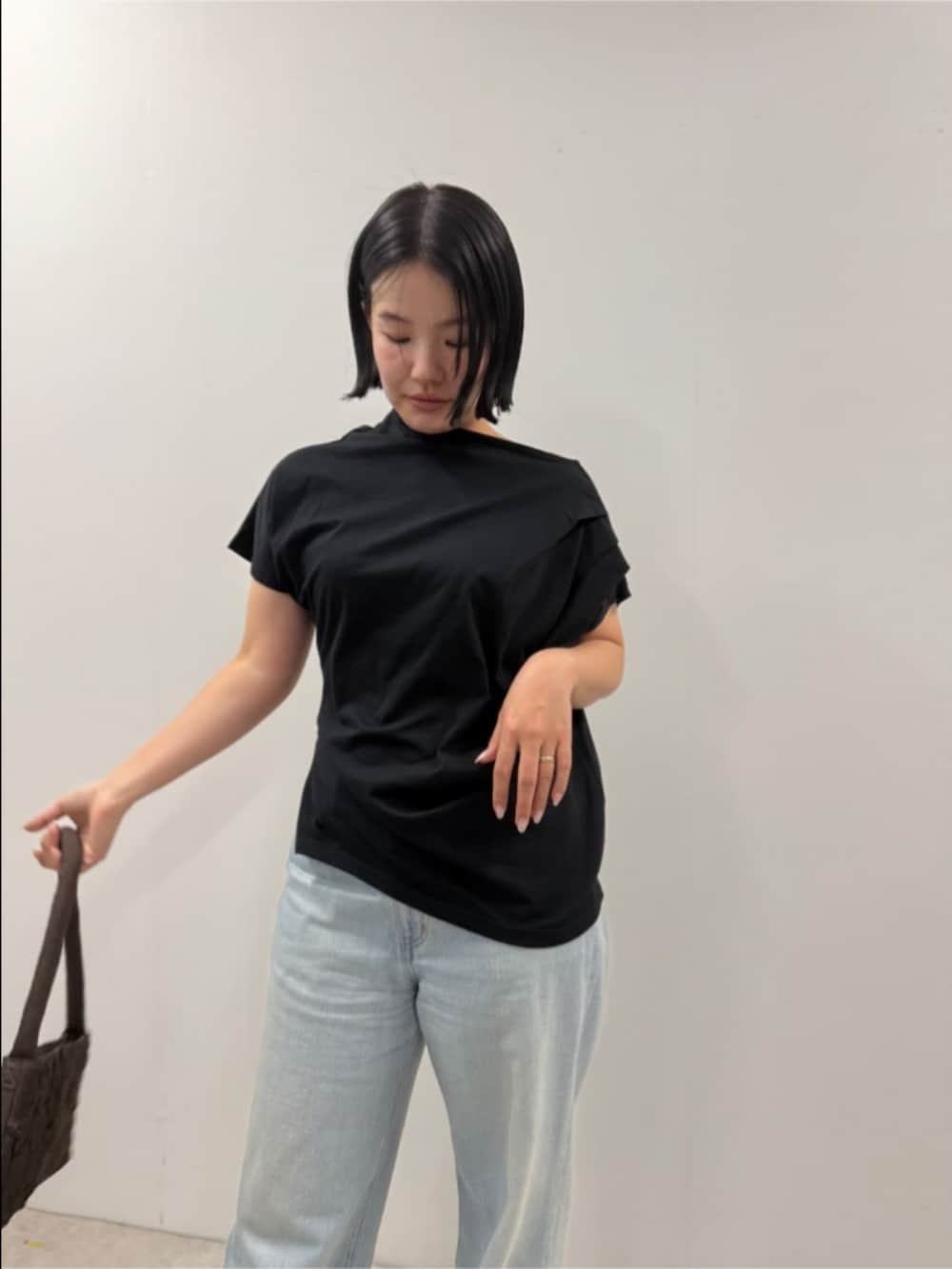 ブラック系のTシャツ/カットソー、ブラウン系のハンドバッグを着用したレディースの夏コーディネートの4枚目の写真