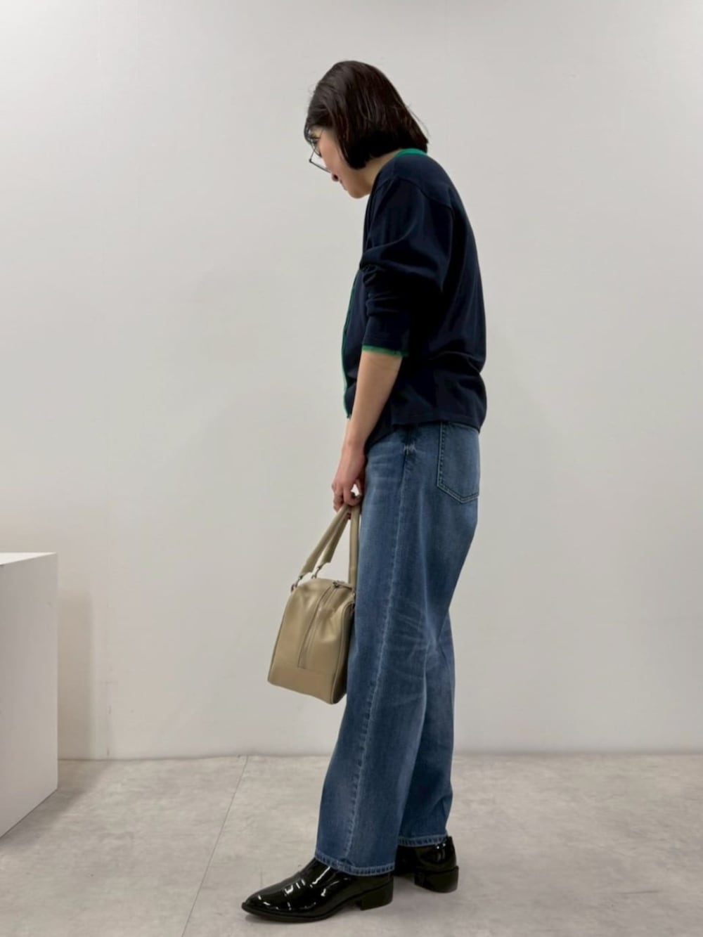 ブラック系のローファー、ブルー系のカーディガン/ボレロ、ブルー系のデニムパンツを着用したレディースの冬コーディネートの4枚目の写真