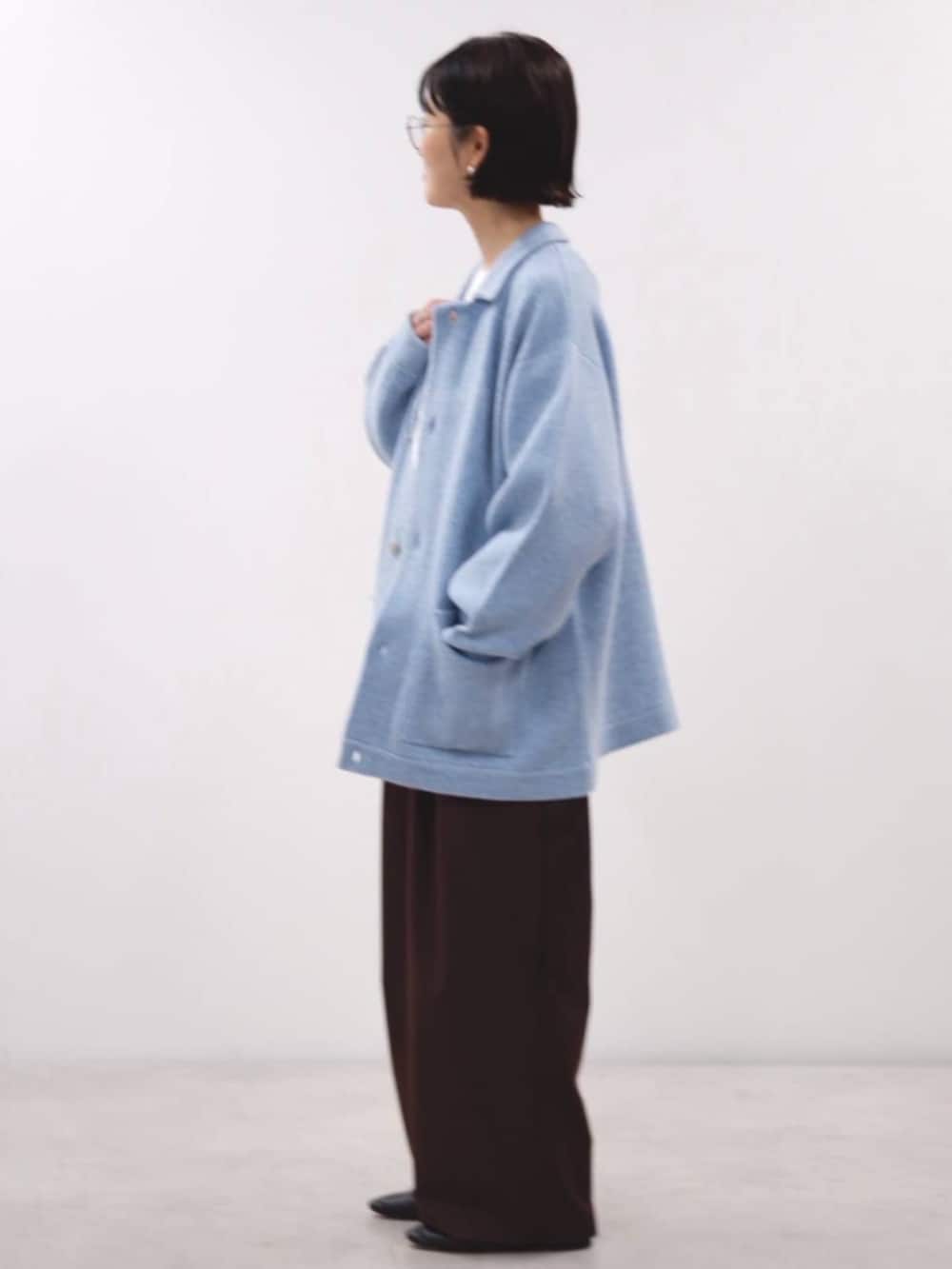 ブラウン系のスラックス、ブルー系のブルゾンを着用したレディースの秋コーディネートの2枚目の写真