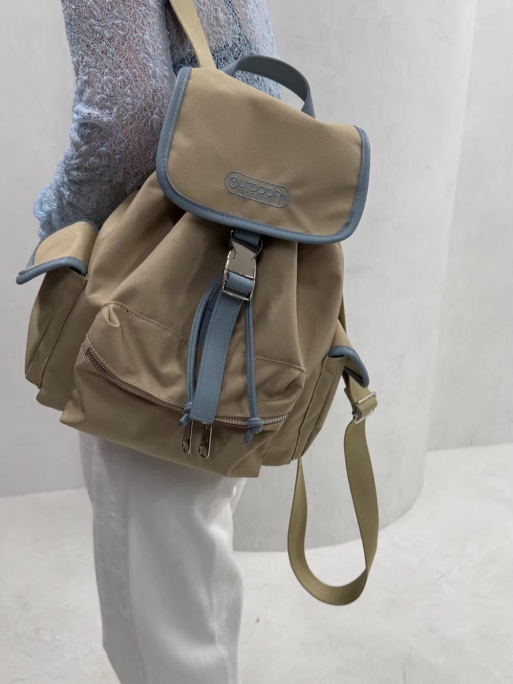 ブルー系のニット/セーター、ベージュ系のバックパック/リュックを着用したレディースの冬コーディネートの3枚目の写真