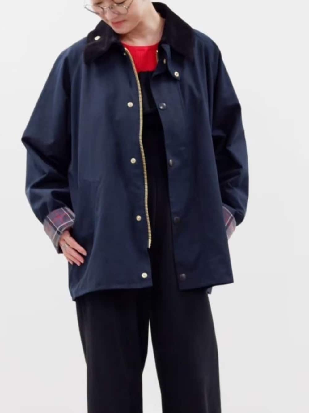 レッド系のニット/セーター、ブルー系のブルゾン、ブラック系のつなぎ/オールインワンを着用したレディースの秋コーディネートの2枚目の写真