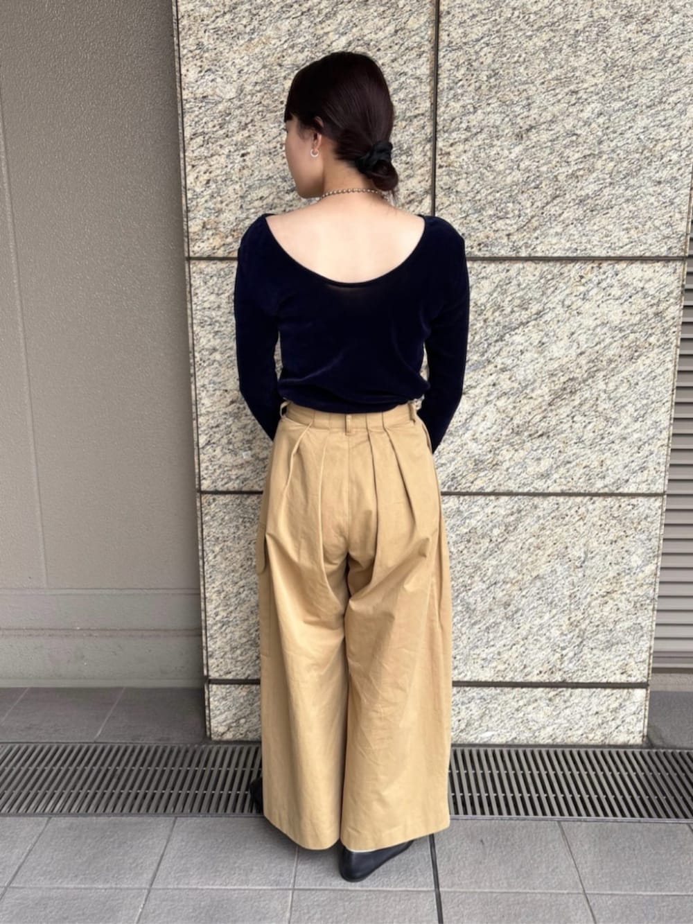 イエロー系のチノパンツを着用したレディースの秋コーディネートの3枚目の写真