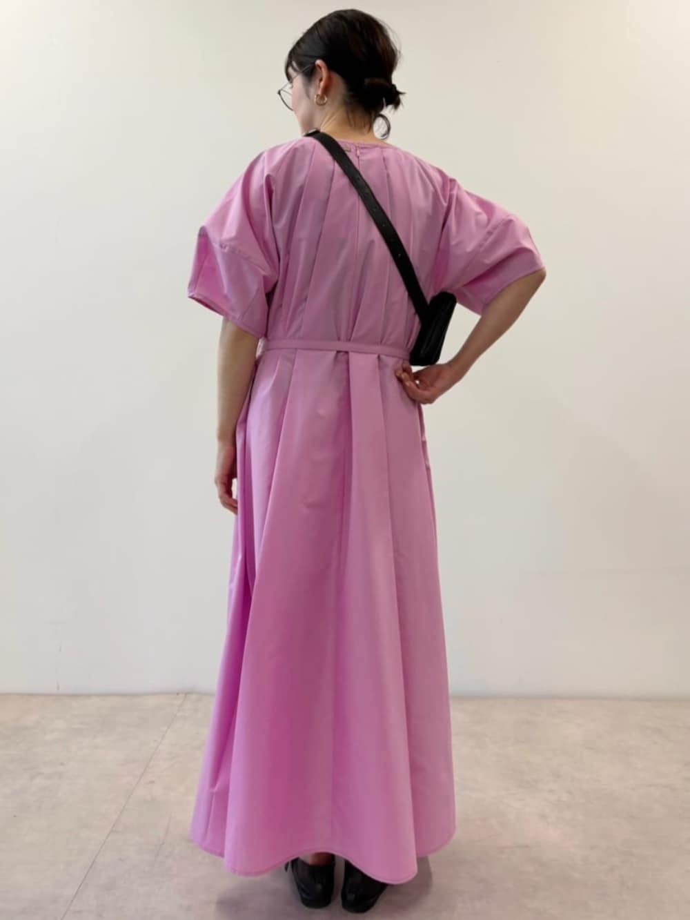 ブラック系のボディバッグ/ウエストポーチ、ピンク系のワンピースを着用したレディースの春コーディネートの3枚目の写真