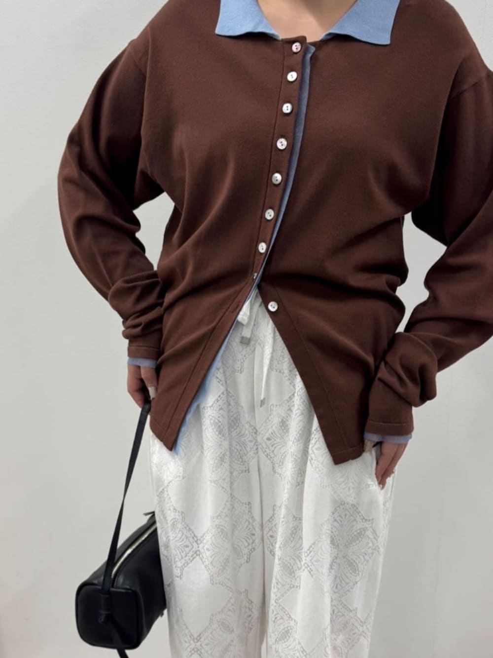 ブラウン系のカーディガン/ボレロ、ホワイト系のその他パンツ、ブラック系のボストンバッグを着用したレディースの冬コーディネートの3枚目の写真