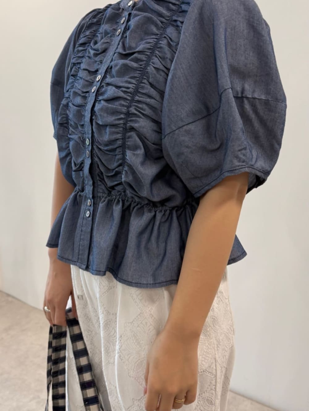 ブルー系のシャツ/ブラウス、ブルー系のトートバッグ、ホワイト系のデニムパンツを着用したレディースの春コーディネートの4枚目の写真