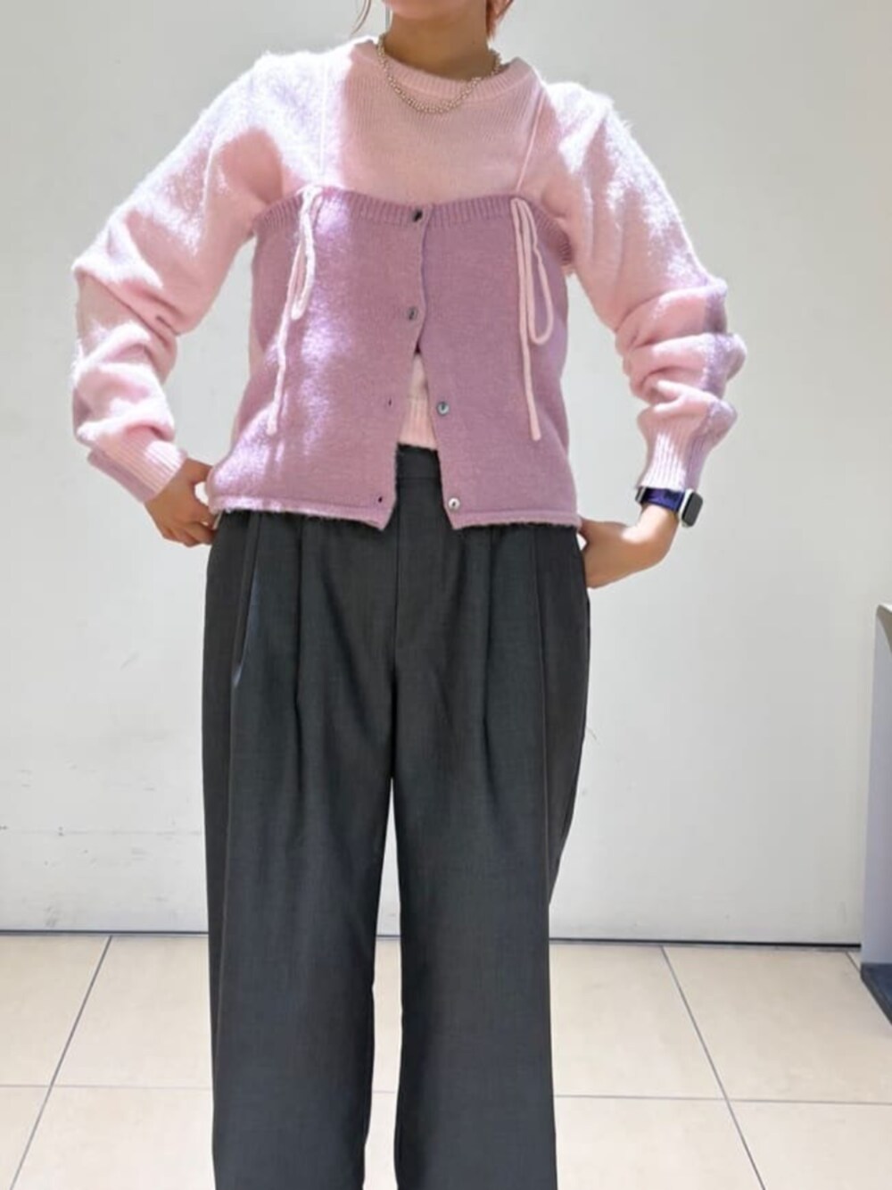 ピンク系のニット/セーター、ピンク系のチューブトップ、グレー系のスラックスを着用したレディースの冬コーディネートの4枚目の写真