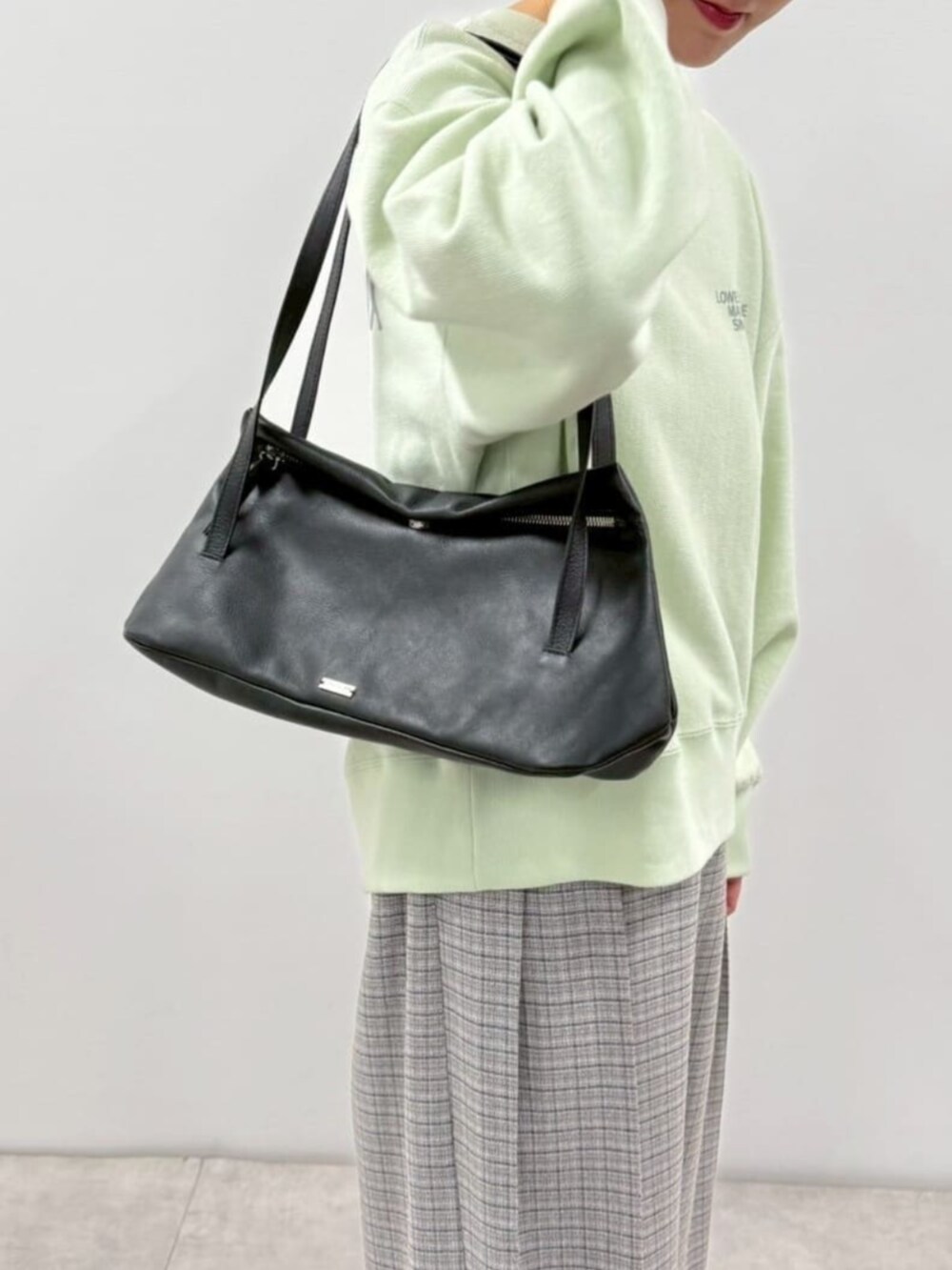 ブラック系のローファー、ブルー系のスウェット、ブラック系のショルダーバッグを着用したレディースの冬コーディネートの8枚目の写真