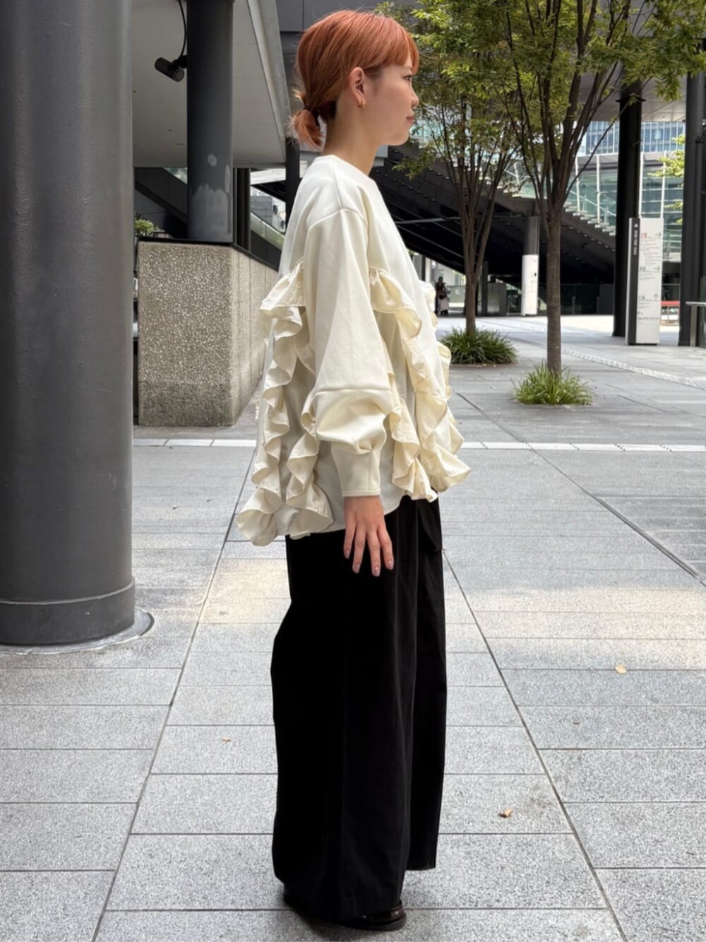 ホワイト系のスウェット、ブラック系のチノパンツを着用したレディースの秋コーディネートの2枚目の写真