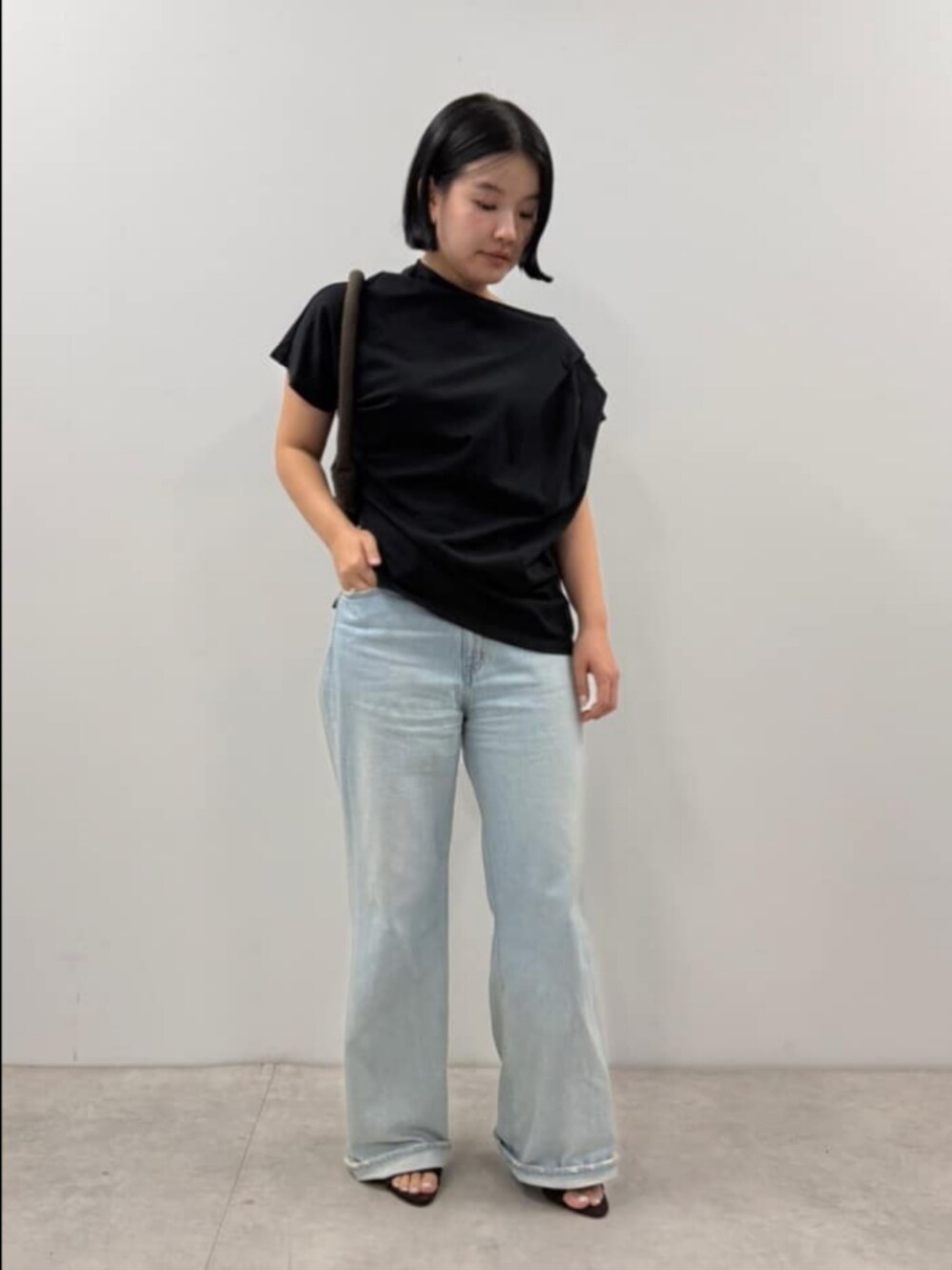 ブラック系のTシャツ/カットソー、ブラウン系のハンドバッグを着用したレディースの夏コーディネートの2枚目の写真