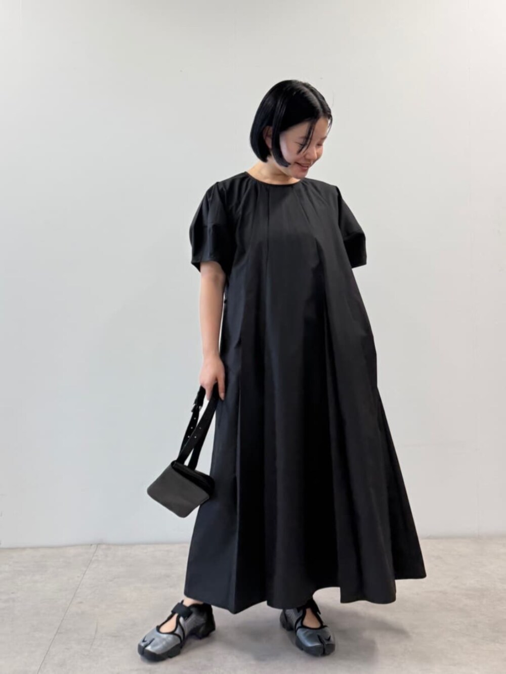 ブラック系のワンピース、ブラック系のボディバッグ/ウエストポーチを着用したレディースの春コーディネートの4枚目の写真