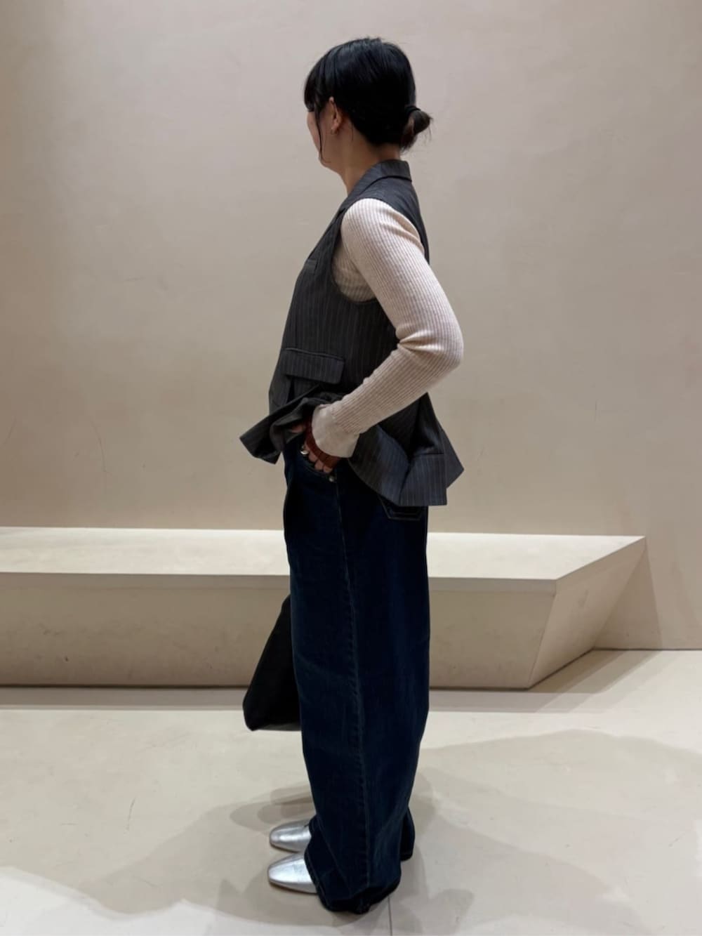 ブラック系のトートバッグ、グレー系のベストを着用したレディースの冬コーディネートの2枚目の写真