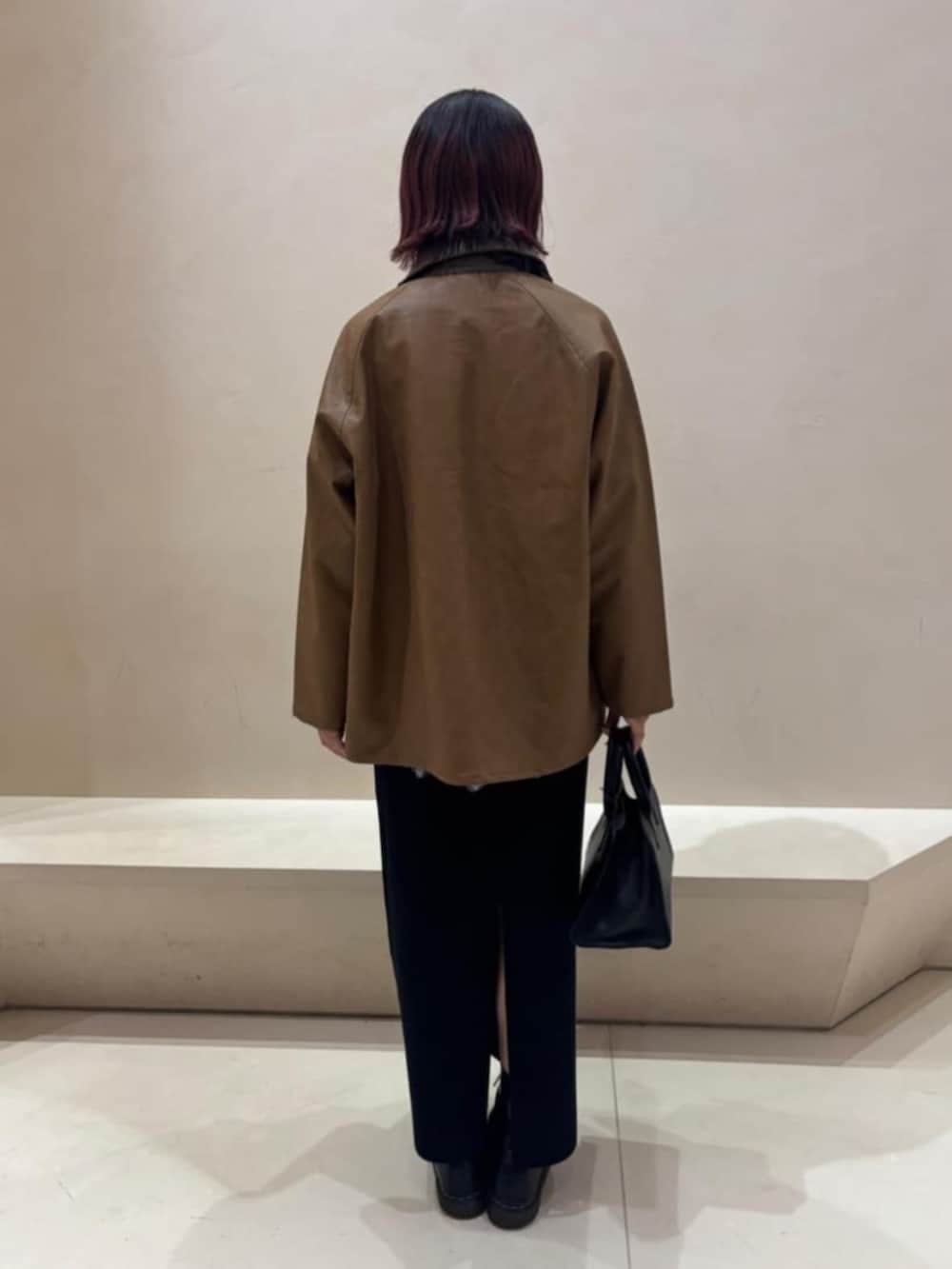 ブラック系のボストンバッグ、ホワイト系のシャツ/ブラウス、ブラック系のスカートを着用したレディースの秋コーディネートの3枚目の写真