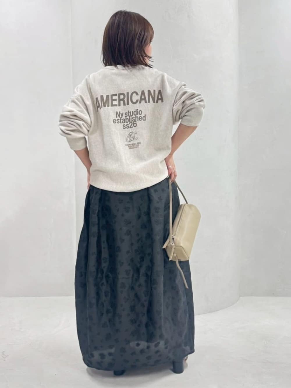 ベージュ系のボストンバッグ、ホワイト系のスウェット、ブラック系のスカートを着用したレディースの春コーディネートの3枚目の写真