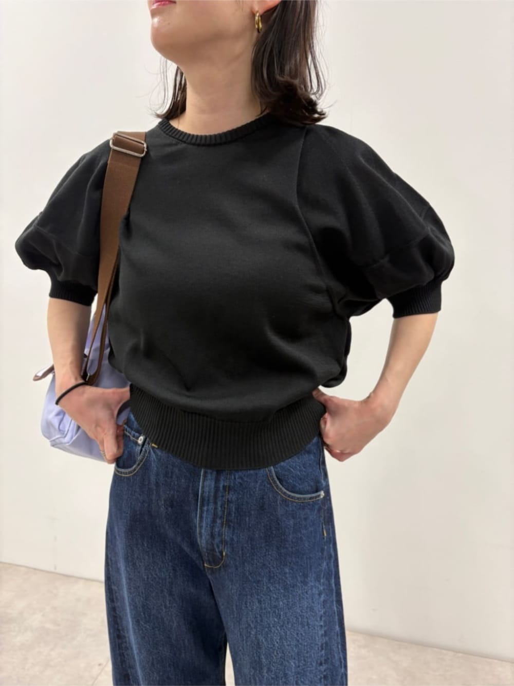 ブルー系のデニムパンツ、ブラック系のニット/セーター、パープル系のバックパック/リュックを着用したレディースの春コーディネートの5枚目の写真