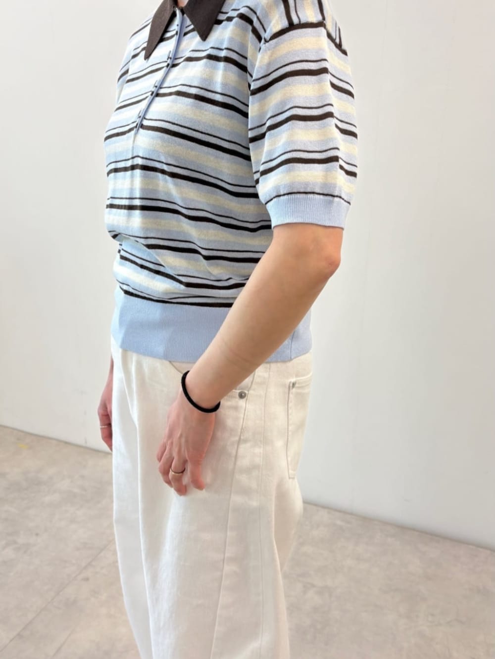 ホワイト系のデニムパンツ、ブルー系のポロシャツを着用したレディースの春コーディネートの4枚目の写真