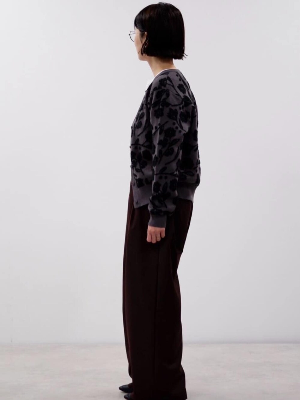 ブラウン系のスラックス、グレー系のカーディガン/ボレロを着用したレディースの秋コーディネートの2枚目の写真