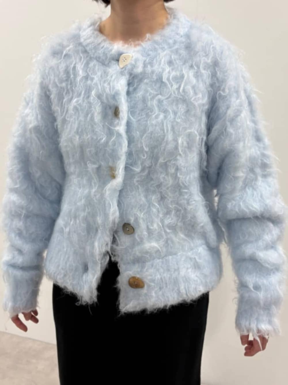 ブルー系のカーディガン/ボレロ、ブラック系のスカート、ブラック系のローファーを着用したレディースの秋コーディネートの6枚目の写真