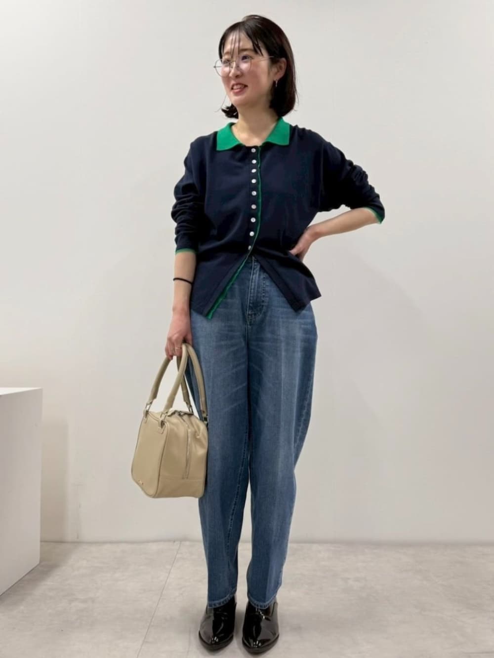 ブラック系のローファー、ブルー系のカーディガン/ボレロ、ブルー系のデニムパンツを着用したレディースの冬コーディネートの2枚目の写真