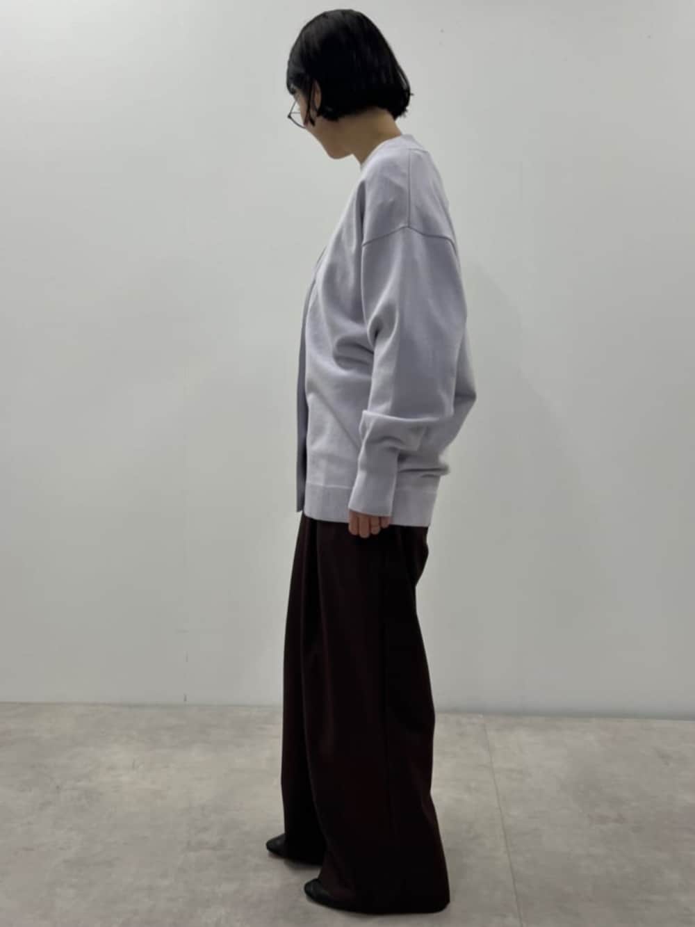 パープル系のカーディガン/ボレロ、ブラウン系のスラックスを着用したレディースの秋コーディネートの4枚目の写真