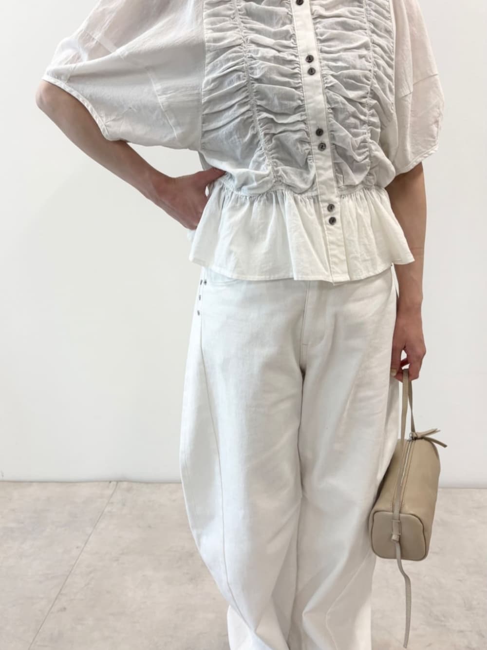 ベージュ系のボストンバッグ、ホワイト系のデニムパンツ、ホワイト系のシャツ/ブラウスを着用したレディースの春コーディネートの3枚目の写真