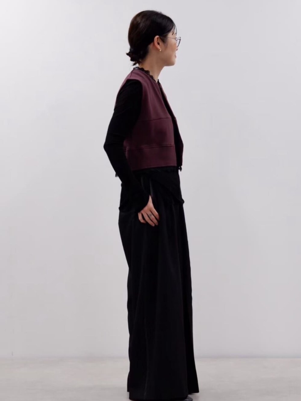 ブラウン系のベスト、ブラック系のスラックスを着用したレディースの秋コーディネートの4枚目の写真