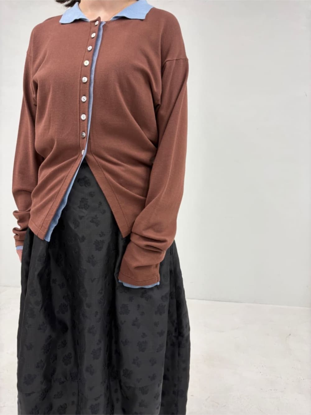 ブラウン系のカーディガン/ボレロ、ブラック系のスカートを着用したレディースの冬コーディネートの6枚目の写真