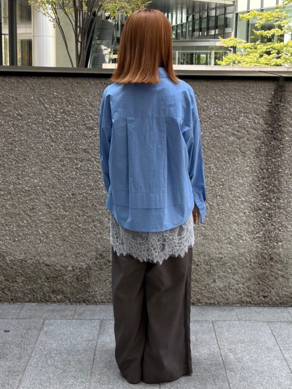 ブルー系のシャツ/ブラウス、グレー系のスラックスを着用したレディースの秋コーディネートの3枚目の写真