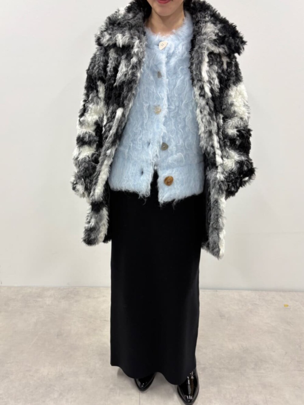 ブルー系のカーディガン/ボレロ、ブラック系のスカート、ブラック系のローファーを着用したレディースの秋コーディネートの5枚目の写真