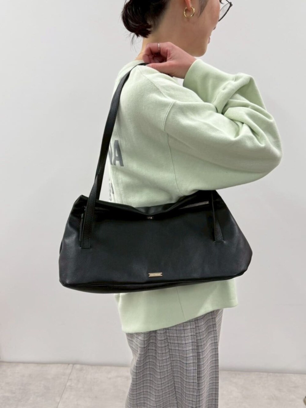 ブラック系のローファー、ブルー系のスウェット、ブラック系のショルダーバッグを着用したレディースの冬コーディネートの9枚目の写真