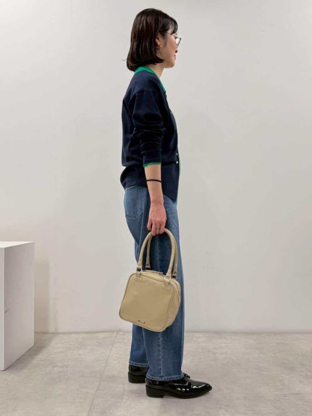 ブラック系のローファー、ブルー系のカーディガン/ボレロ、ブルー系のデニムパンツを着用したレディースの冬コーディネートの5枚目の写真