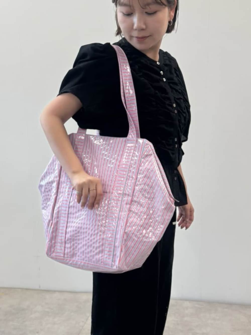 ブラック系のシャツ/ブラウス、ブラック系のその他パンツ、ピンク系のトートバッグを着用したレディースの春コーディネートの3枚目の写真