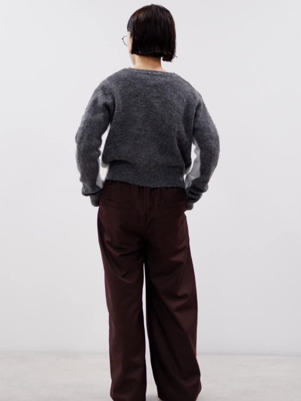 ブラウン系のスラックス、グレー系のカーディガン/ボレロを着用したレディースの秋コーディネートの4枚目の写真