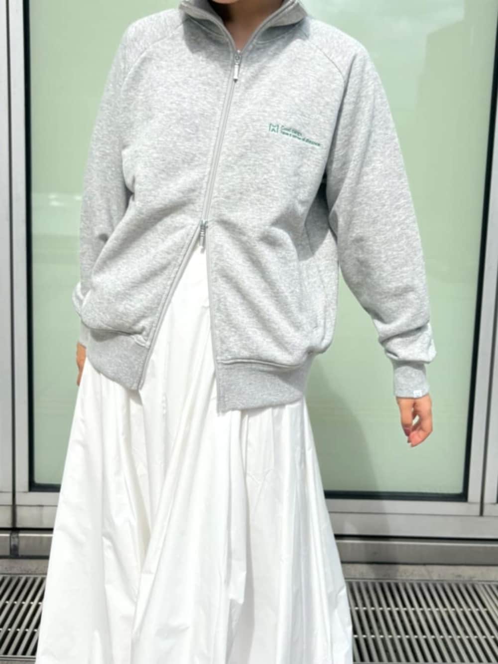 ホワイト系のスカート、グレー系のカーディガン/ボレロを着用したレディースの秋コーディネートの4枚目の写真