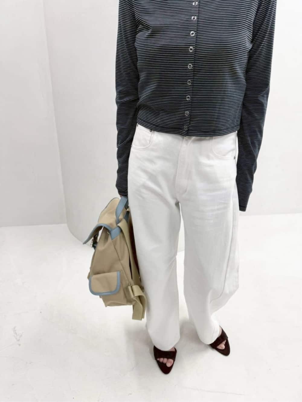 ベージュ系のバックパック/リュック、ホワイト系のデニムパンツ、ブルー系のカーディガン/ボレロを着用したレディースの春コーディネートの8枚目の写真