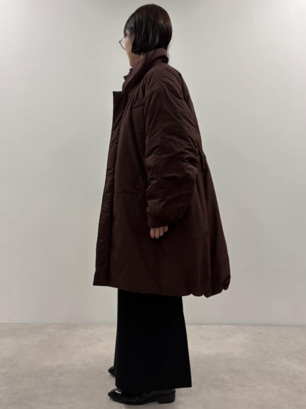 ブラック系のボストンバッグ、ブラウン系のブルゾン、ブルー系のカーディガン/ボレロを着用したレディースの秋コーディネートの2枚目の写真