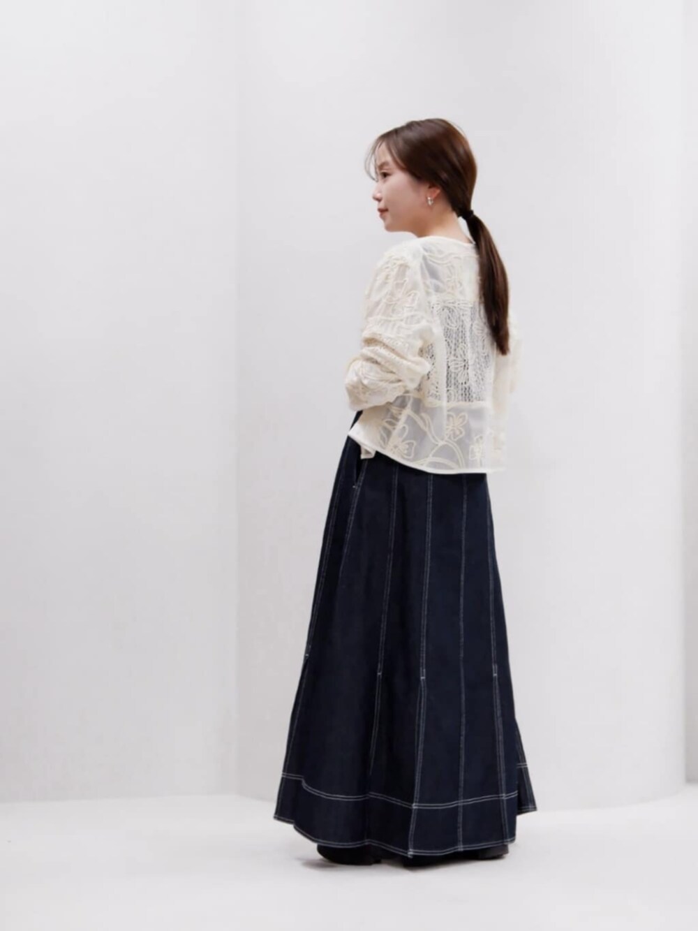 ブラック系のハンドバッグ、ホワイト系のシャツ/ブラウス、ブルー系のワンピースを着用したレディースの秋コーディネートの2枚目の写真