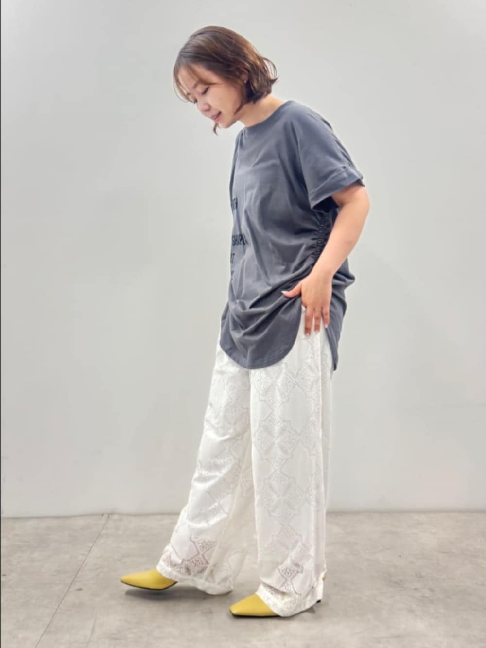 グレー系のTシャツ/カットソー、ホワイト系のその他パンツ、ブラック系のボストンバッグを着用したレディースの夏コーディネートの3枚目の写真
