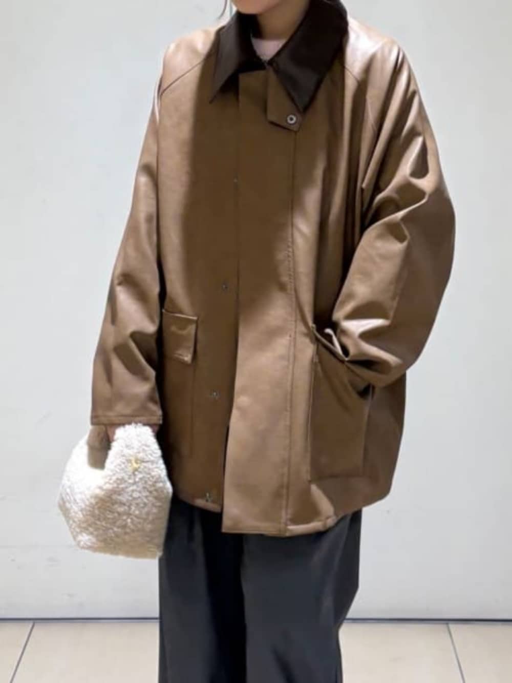 ピンク系のカーディガン/ボレロ、イエロー系のブルゾン、グレー系のスラックスを着用したレディースの冬コーディネートの4枚目の写真