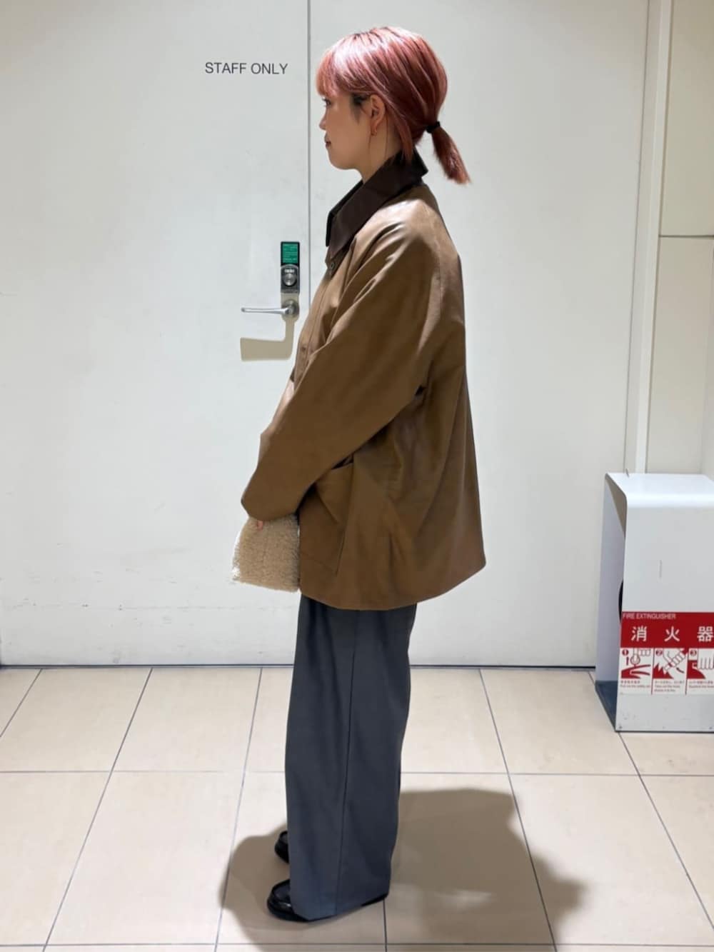 ピンク系のカーディガン/ボレロ、イエロー系のブルゾン、グレー系のスラックスを着用したレディースの冬コーディネートの2枚目の写真