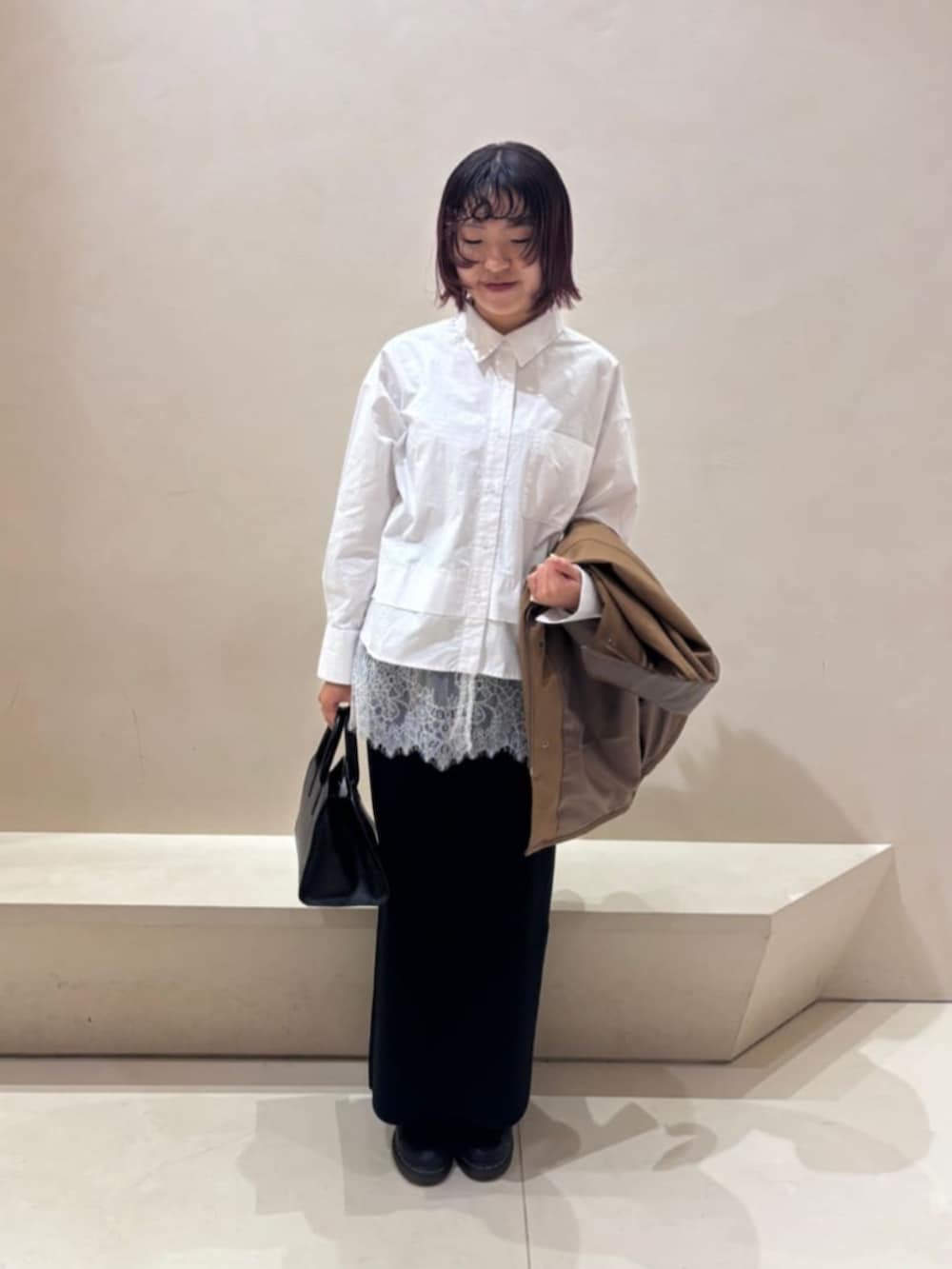 ブラック系のボストンバッグ、ホワイト系のシャツ/ブラウス、ブラック系のスカートを着用したレディースの秋コーディネートの4枚目の写真